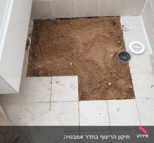 רצפה פתוחה עם אריחים מוסרים ועפר חשוף